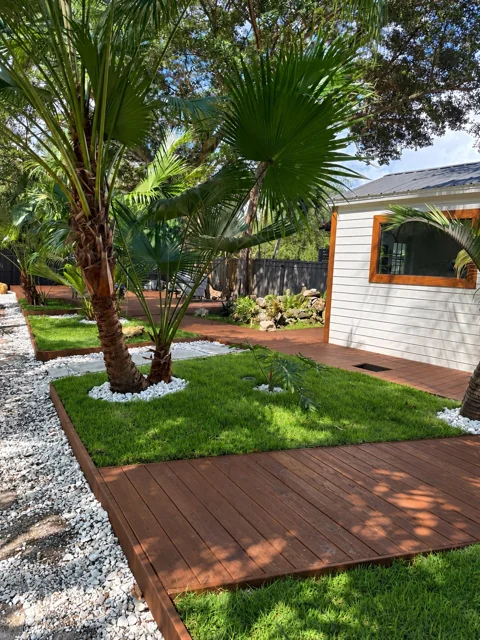 Custom deck with curved garden borders beside a home
