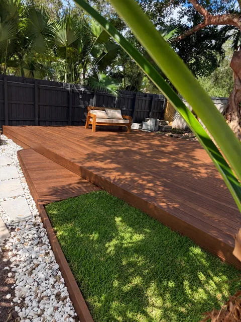 Wood deck with outdoor seating beneath trees