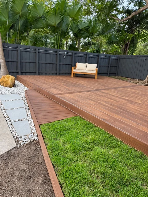 Custom deck and curved entry beside a lawn and stone path