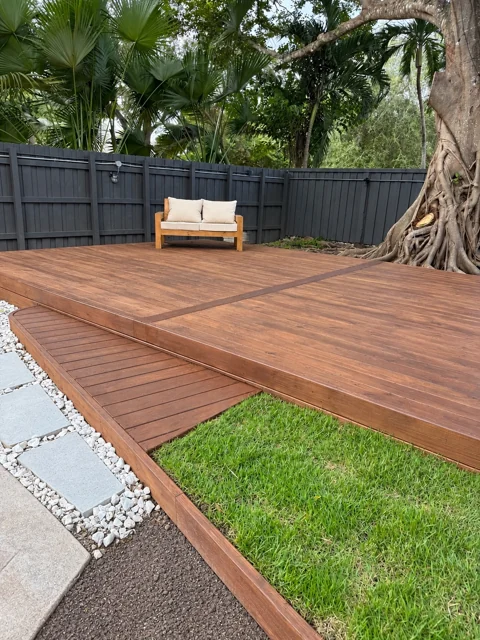 Wood deck with rounded step and a garden area beside it